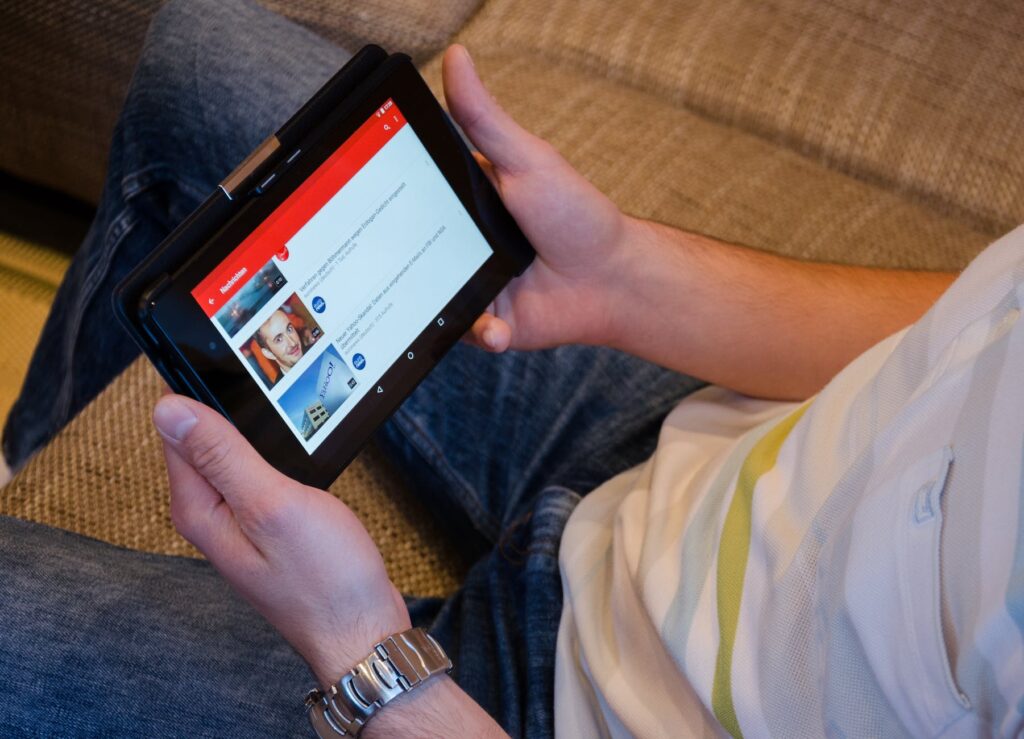 person holding tablet computer showing videos